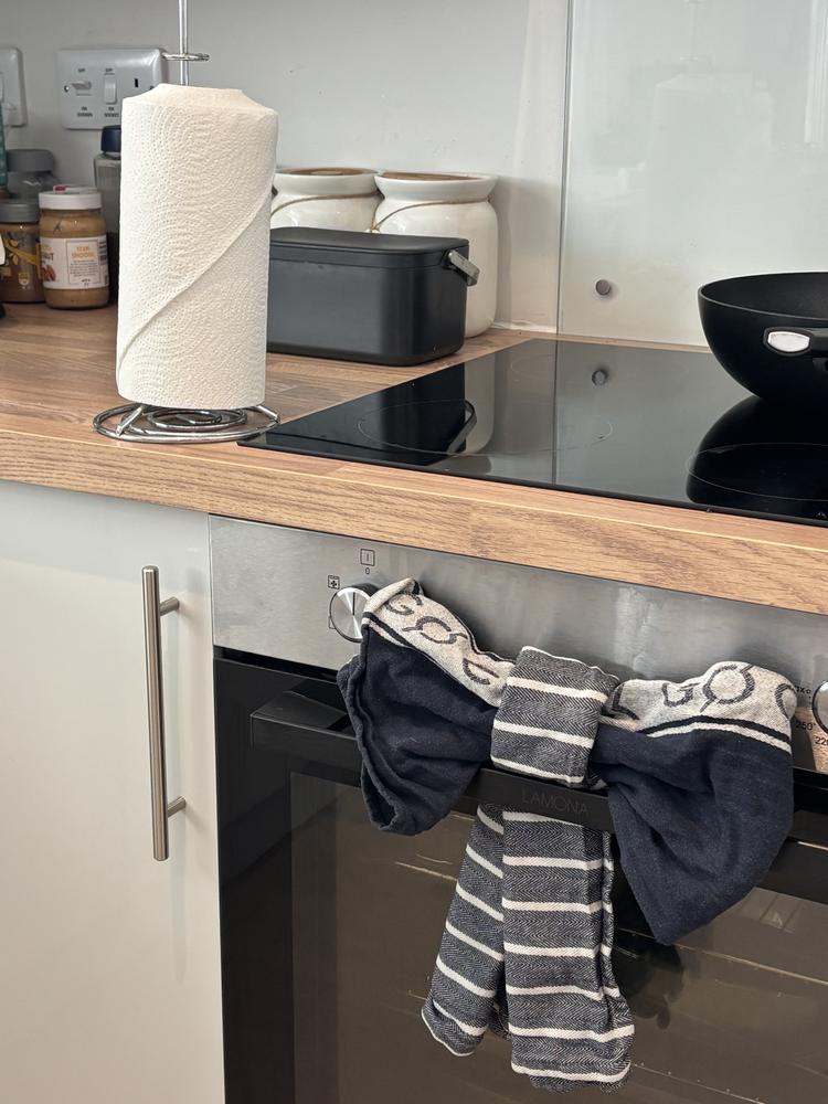 A clean kitchen worktop and hob with neatly tied tea towels on the oven door